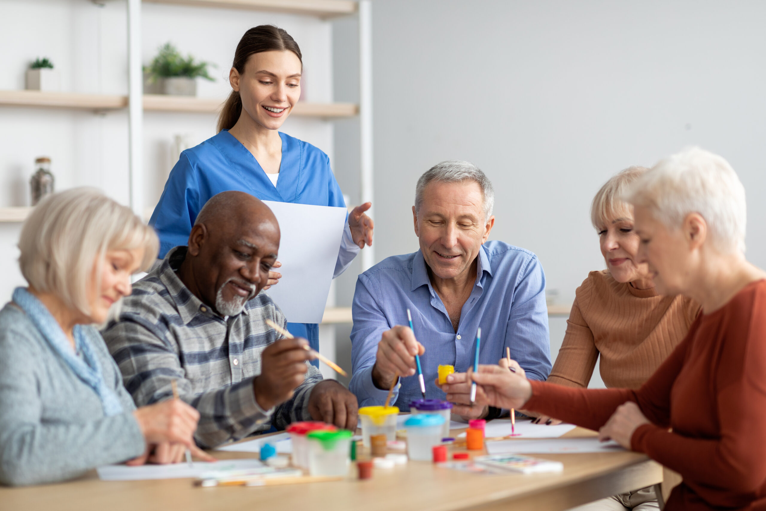 Happy elderly men and women doing arts and crafts together